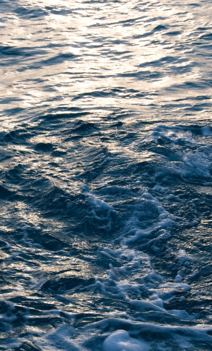 Ocean surface at sunset with waves and deep blue water, used on Hogan Lovells’ deepwater ports case study page to represent offshore energy and MARAD deepwater port projects.